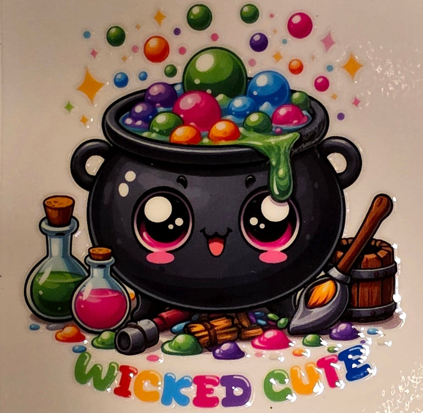 Cartoon cauldron with colorful candies and 'Wicked Cute' text on a marble background
