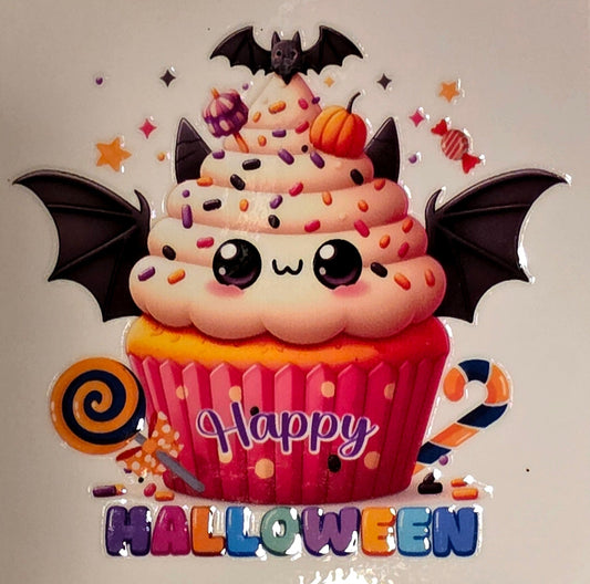 Halloween-themed cupcake with bats and candy on a marble background